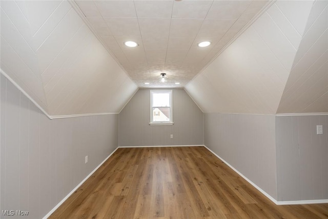 additional living space with lofted ceiling and hardwood / wood-style floors