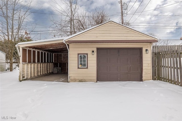 snow covered garage featuring a carport