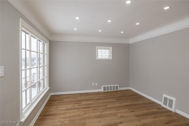 spare room with crown molding and wood-type flooring