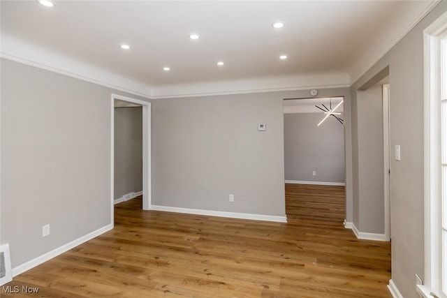 unfurnished room with crown molding and hardwood / wood-style floors