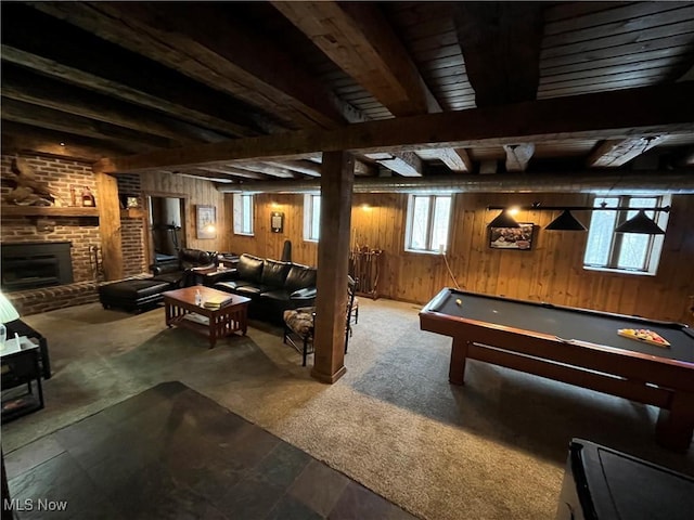 game room featuring billiards, carpet flooring, a brick fireplace, beamed ceiling, and wood walls