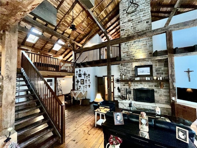 living room featuring beamed ceiling, wood-type flooring, high vaulted ceiling, and wooden ceiling