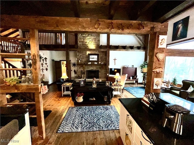 interior space featuring hardwood / wood-style flooring, a brick fireplace, and beamed ceiling