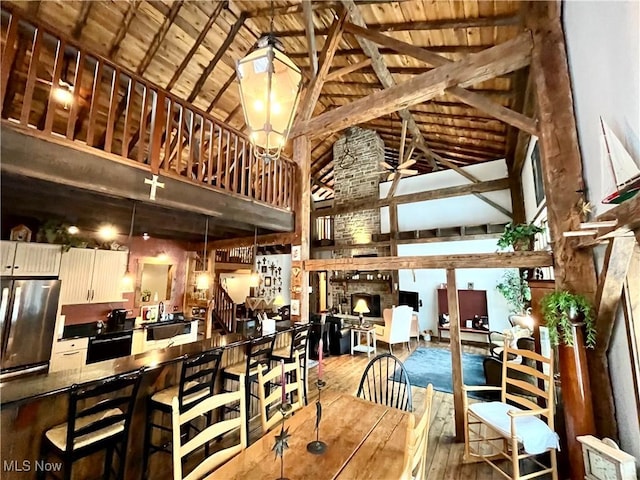 dining space with sink, wood-type flooring, high vaulted ceiling, wooden ceiling, and beam ceiling