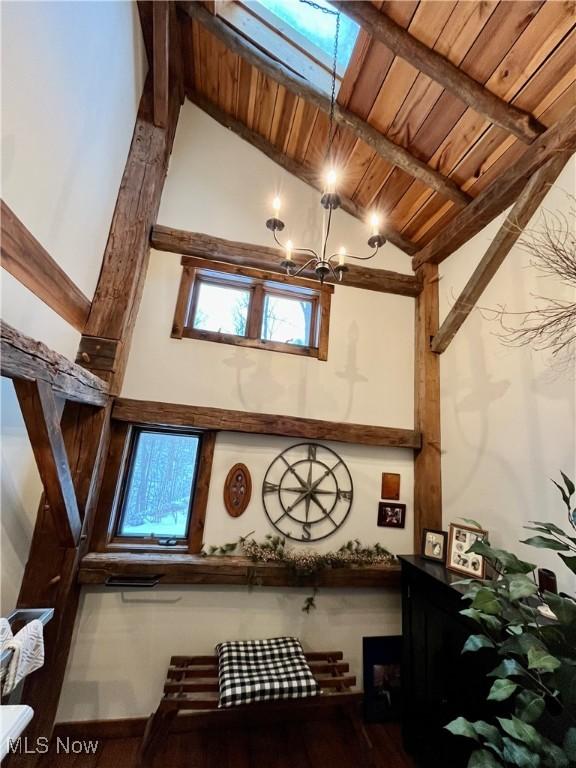 interior space with beamed ceiling, wooden ceiling, and a chandelier