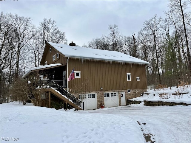 snow covered property featuring a garage