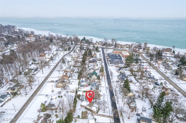 snowy aerial view featuring a water view