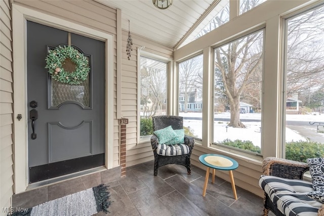 sunroom featuring plenty of natural light and vaulted ceiling