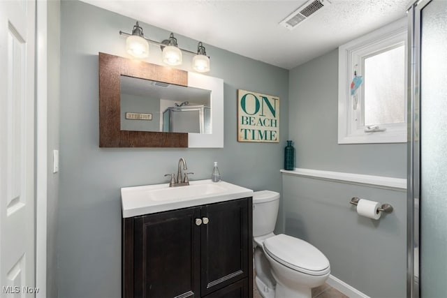 bathroom featuring vanity, toilet, and a shower with door