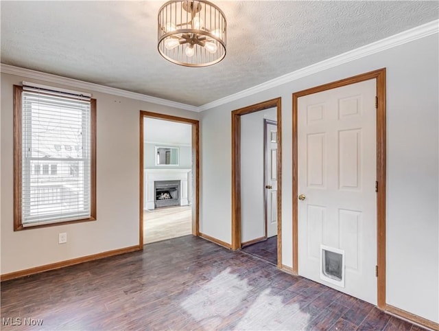 spare room with crown molding, an inviting chandelier, dark wood-type flooring, and a textured ceiling