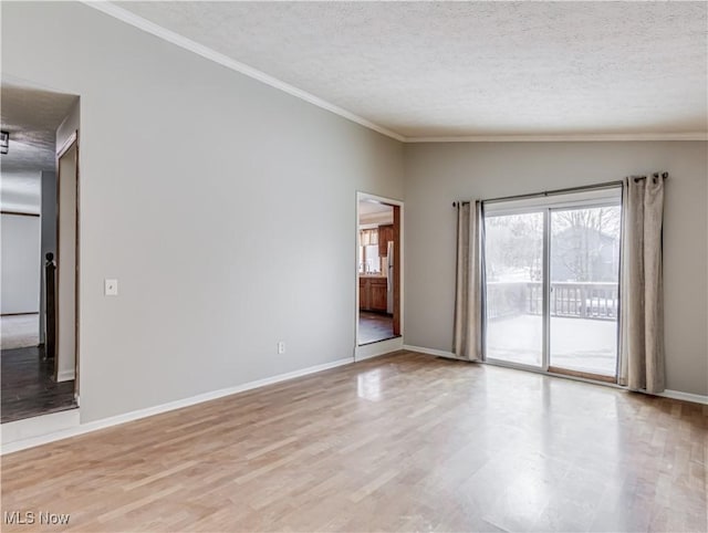 empty room featuring lofted ceiling, crown molding, a textured ceiling, and light wood-type flooring