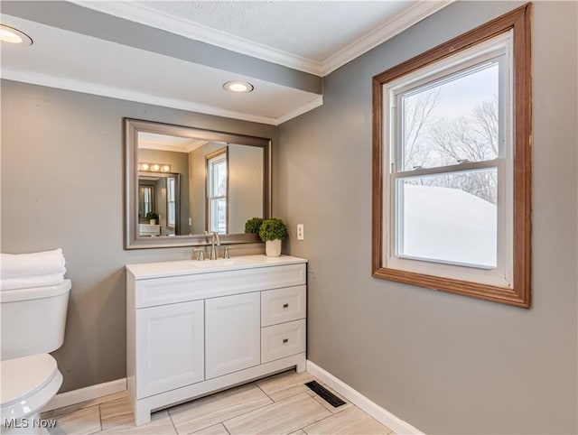 bathroom with vanity, a wealth of natural light, ornamental molding, and toilet