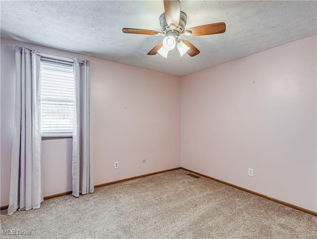 carpeted spare room with ceiling fan and a textured ceiling