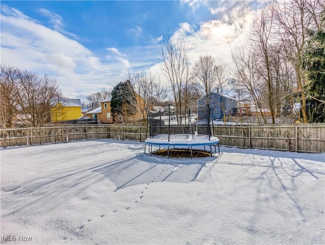 snowy yard featuring a trampoline