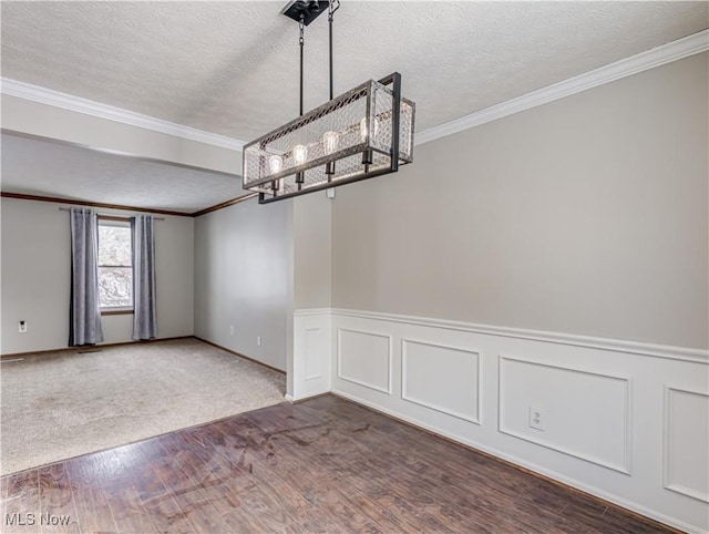 unfurnished dining area featuring crown molding, dark wood-type flooring, an inviting chandelier, and a textured ceiling