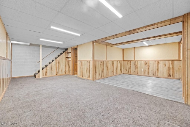 basement with a drop ceiling and carpet flooring