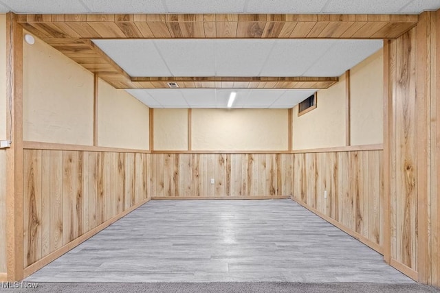 basement with wooden walls and light hardwood / wood-style floors