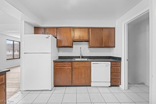 kitchen featuring white appliances, sink, and light tile patterned floors