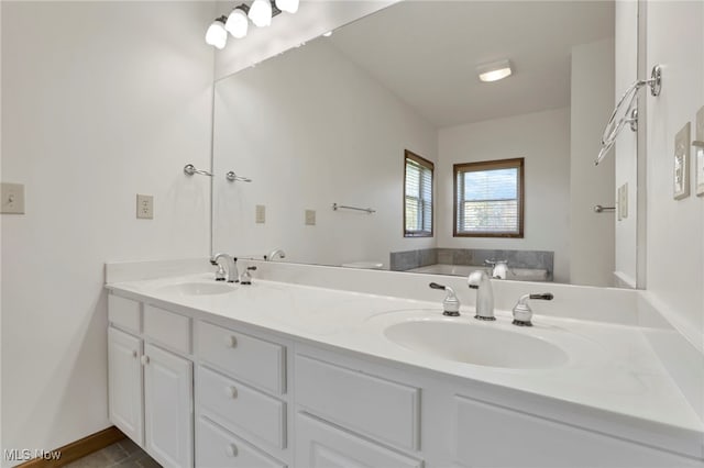 bathroom with toilet, vanity, and a bath