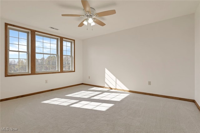 spare room with ceiling fan and light colored carpet