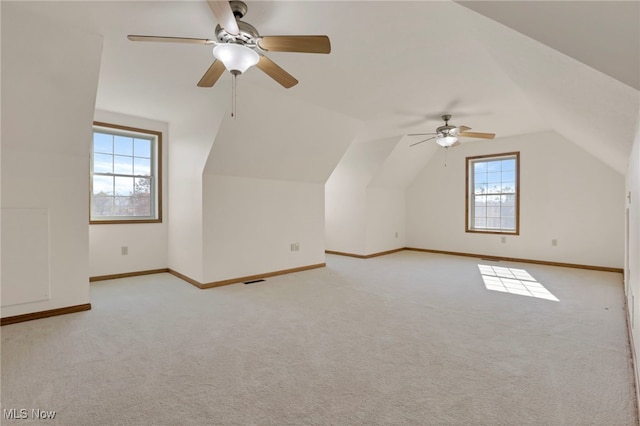 additional living space featuring vaulted ceiling, plenty of natural light, and light carpet