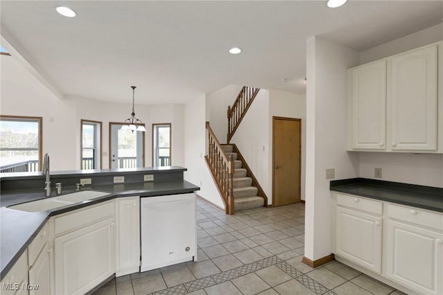 kitchen featuring light tile patterned flooring, sink, hanging light fixtures, white dishwasher, and white cabinets