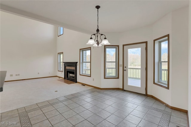 unfurnished living room featuring an inviting chandelier and light carpet