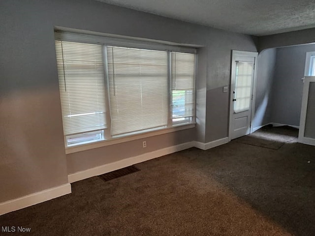 carpeted foyer with a textured ceiling