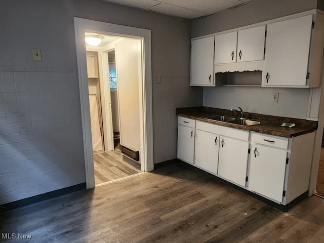 kitchen featuring a drop ceiling, sink, dark hardwood / wood-style floors, and white cabinets