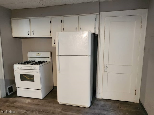 kitchen with white appliances, dark hardwood / wood-style floors, and white cabinets