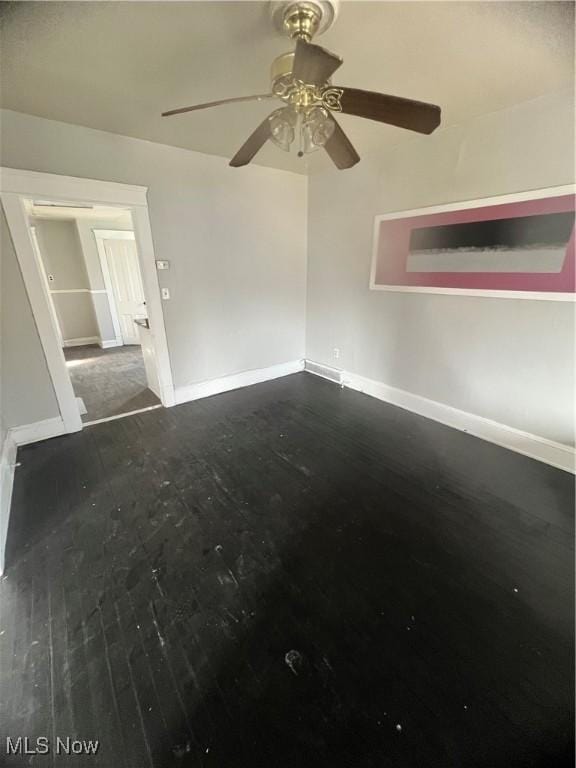 spare room with dark wood-type flooring and ceiling fan