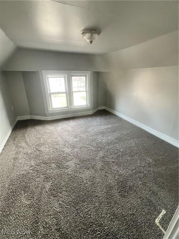 bonus room featuring carpet floors and vaulted ceiling