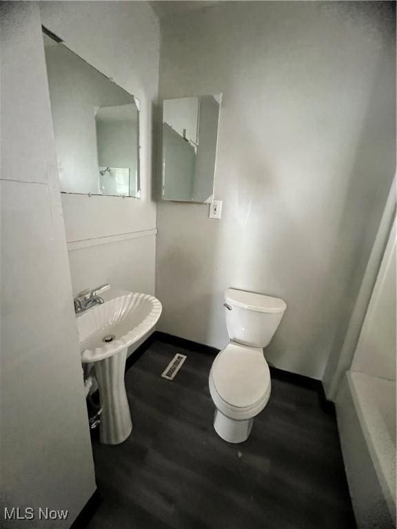 bathroom with wood-type flooring and toilet