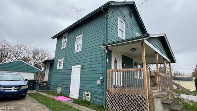 view of side of home with an outbuilding, a porch, and a garage