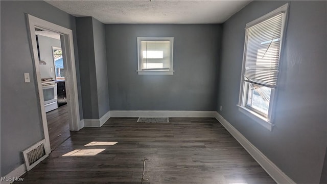 spare room with dark wood-type flooring and a textured ceiling