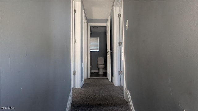 hallway with dark colored carpet