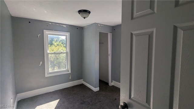 unfurnished bedroom with dark carpet