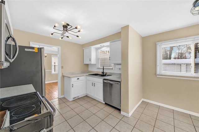 kitchen with white cabinetry, appliances with stainless steel finishes, sink, and light tile patterned floors