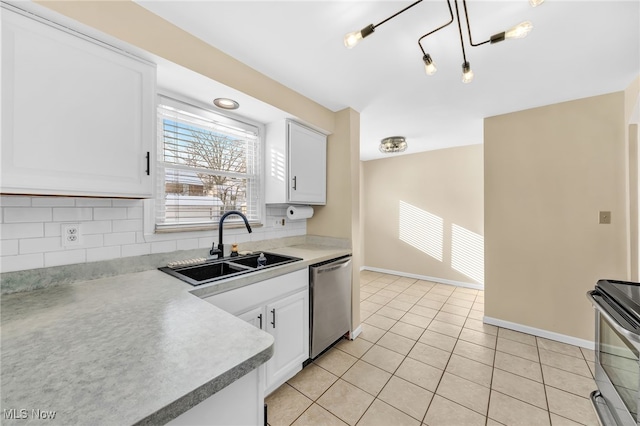 kitchen with appliances with stainless steel finishes, pendant lighting, white cabinetry, sink, and light tile patterned floors