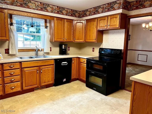 kitchen featuring decorative light fixtures, a chandelier, sink, and black appliances