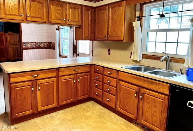 kitchen featuring sink, hanging light fixtures, kitchen peninsula, dishwasher, and a wealth of natural light