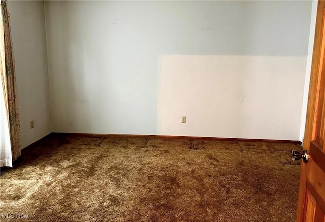 carpeted empty room featuring lofted ceiling