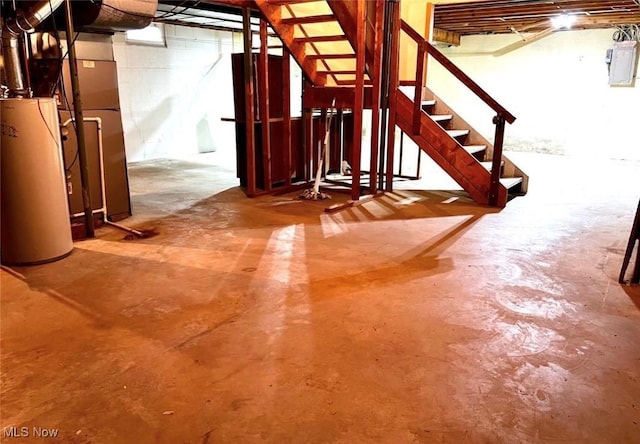basement featuring electric panel and water heater