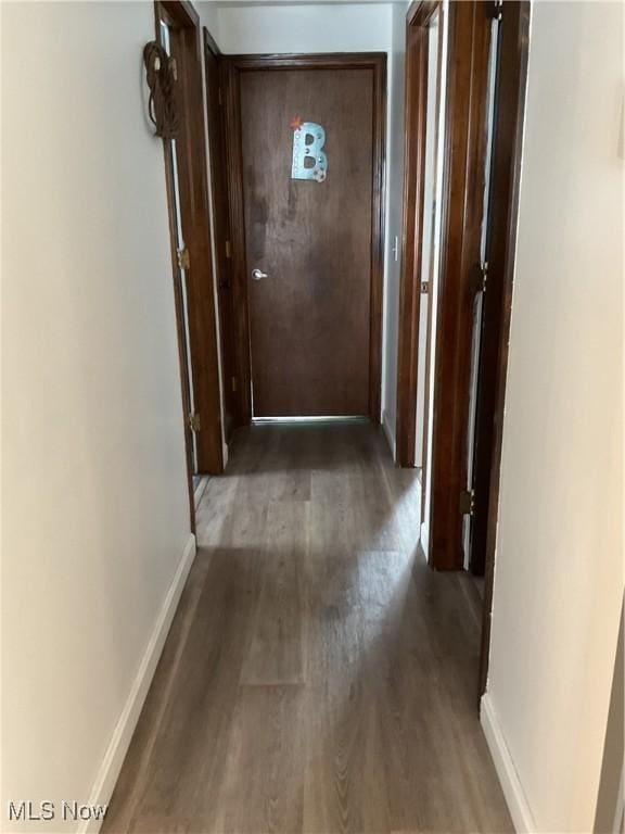 corridor with dark hardwood / wood-style flooring