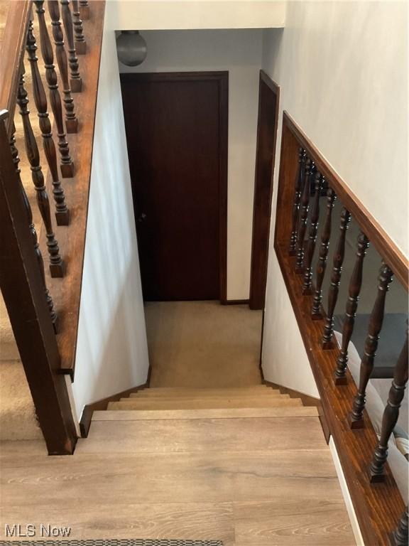 stairway featuring baseboards and wood finished floors