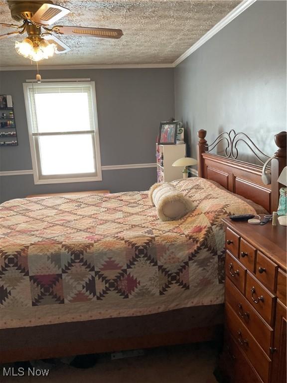 bedroom featuring crown molding, ceiling fan, and a textured ceiling