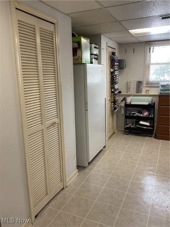 kitchen with a paneled ceiling and white refrigerator