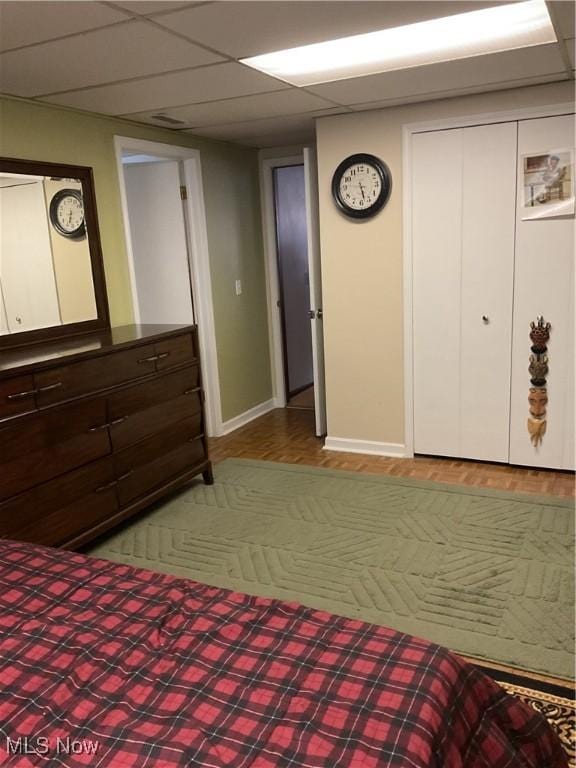 unfurnished bedroom featuring a drop ceiling and a closet