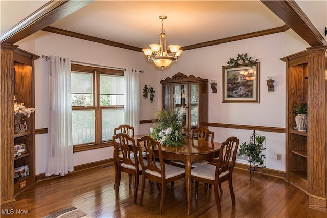 dining space featuring crown molding, dark wood-type flooring, and a chandelier