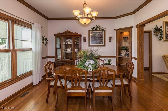 dining area featuring crown molding, dark wood-type flooring, and an inviting chandelier